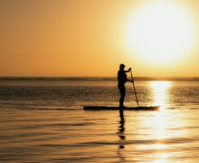 silhouette of man riding on boat during sunset